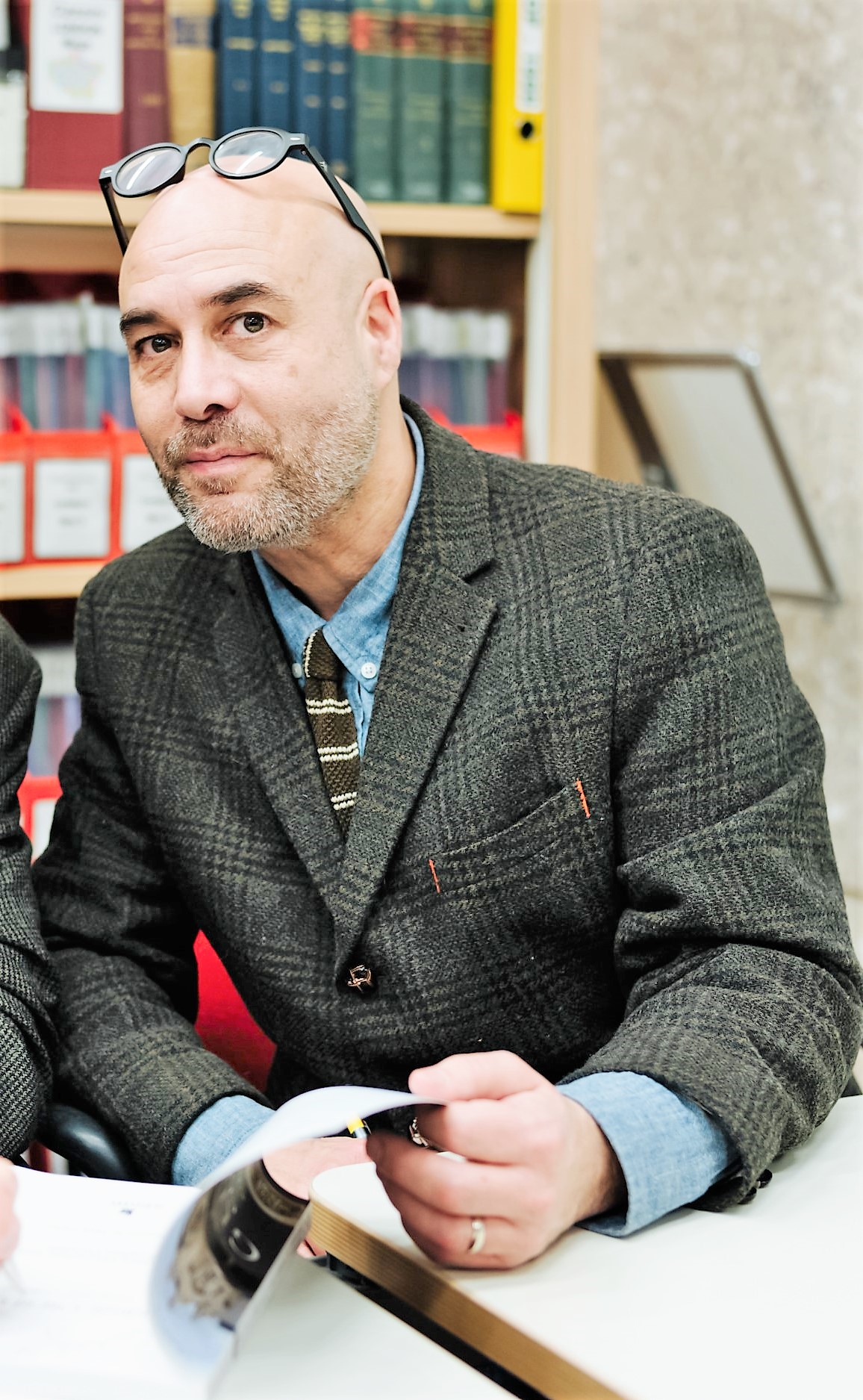 a man wearing a suit and tie sitting at a table