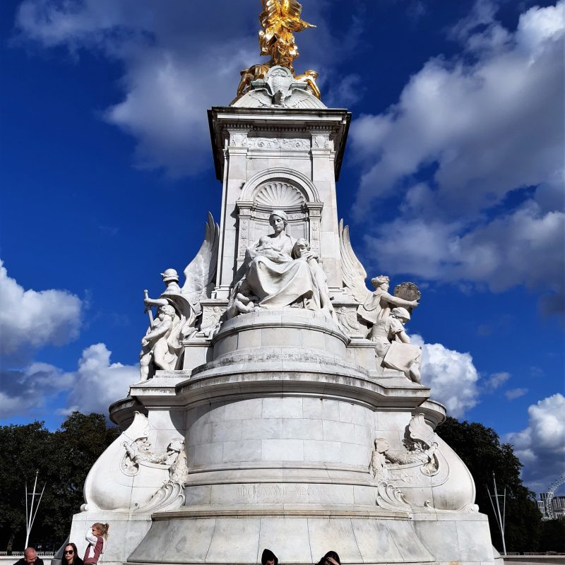 a group of people standing in front of Victoria Memorial, London