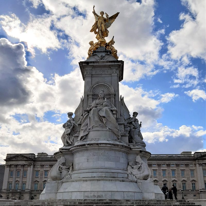 a large clock tower in front of Victoria Memorial, London
